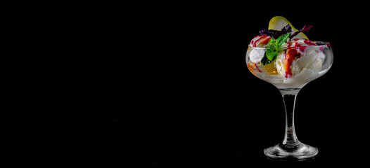 fruit sorbet ice cream in a glass bowl on black wooden table background