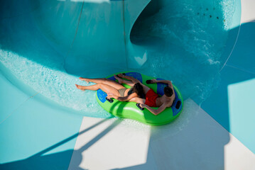 Girl and boy in water Park. Fun on the water. Teen girl and boy having fun in the water slider ....