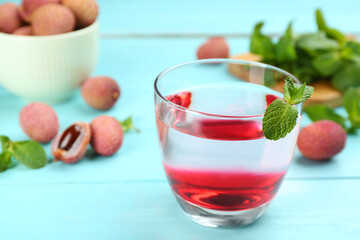 Lychee cocktail with mint on cyan wooden table, closeup