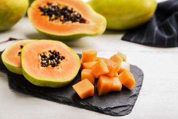 Fresh cut papaya fruits on white wooden table