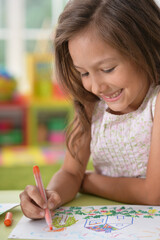 cute smiling girl drawing at home