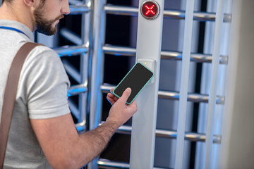 Man applying smartphone to scanner at checkpoint