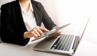 businesswoman hand using smart phone, tablet payments and holding credit card online shopping, omni channel, digital tablet docking keyboard computer at office in sun light