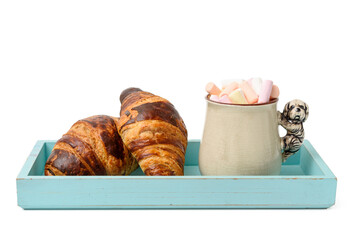 ceramic mug with cocoa and marshmallows, baked croissant on a wooden serving plate