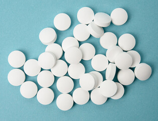 White round pill for healthcare. Medical treatment, blue background