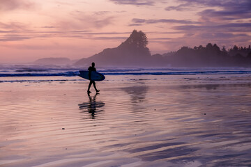Tofino Vancouver Island Pacific rim coast, surfers with board during sunset at the beach, surfers...