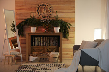 Cozy room interior with console table and conifer garland near wooden wall