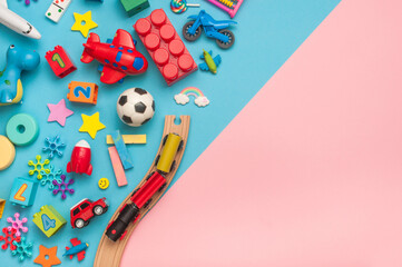 Set of wooden and plastic kids toys on blue and pink background