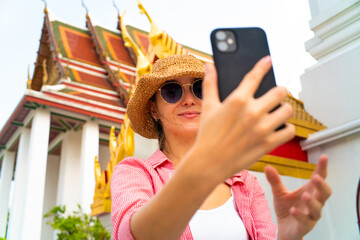 Tourist women take selfie smartphone photo travel in buddha temple