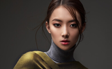 Beautiful Asian woman in a green shawl. Beauty of mysterious Chinese girl with flowing hair....