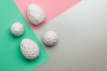 White Easter eggs with geometric patterns on color blocks background