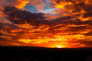 Fondo anaranjado y azul de cielo al atardecer  con la silueta del horizonte