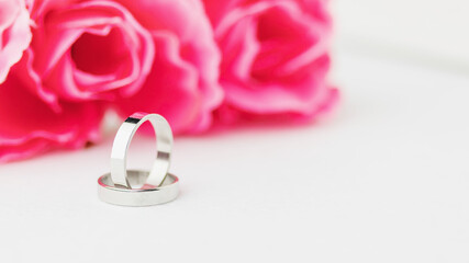 Wedding rings lie near a beautiful bouquet as bridal accessories.Wedding rings and roses bouquet.concept for a wedding card.