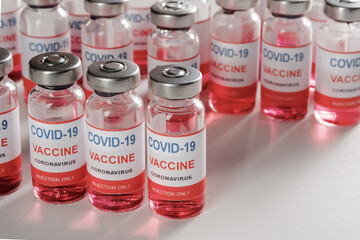 glass vaccine vials for vaccination against COVID-19 SARS-CoV-2 coronavirus pandemic on white background