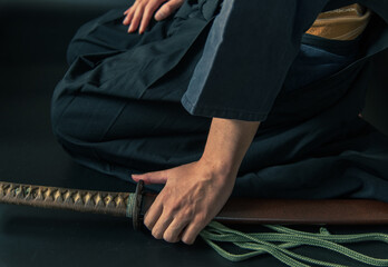 刀を携えて正座する人物 © Josiah.S