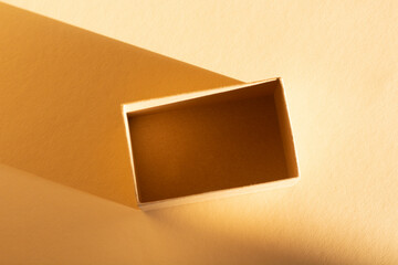 brown cardboard box on beige background and its shadow