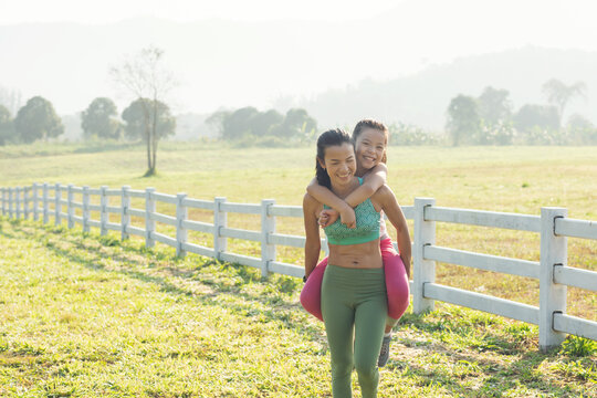 Cute Young Daughter On A Piggy Back Ride With Mother Her Spending Time In Countryside