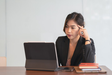 Asian businesswoman gets stressed while having a problem at work in the office.
