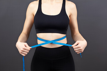 Woman measuring her waist. healthy lifestyle, sport and weight loss concept.