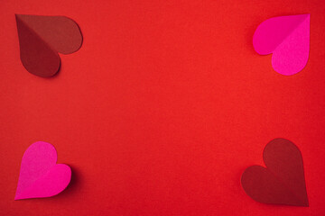 Cutted and folded paper Red hearts on an red paper textured background. Card for Valentine's Day with copy space area for text.