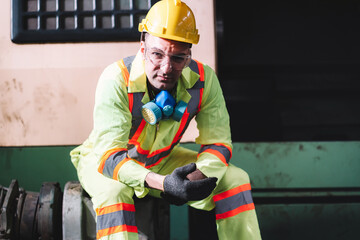 Portrait of factory worker man wearing hardhat and safety protection  looking at camera sitting in gloves to prepare for work