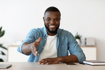 Smiling Black Businessman Giving Hand For Handshake At Camera, Offering Partnership