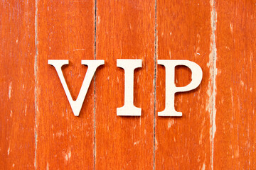 Alphabet letter in word VIP (abbreviation of very important person) on old red color wood plate...