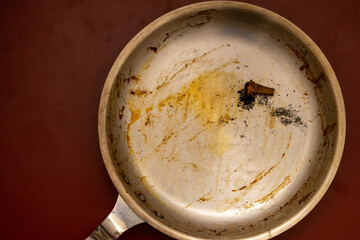 Dirty pan with extinguished cigarette.