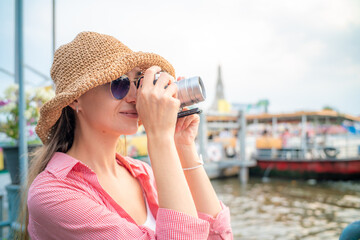 Beautiful tourist women with camera take photo while travel in Bangkok city