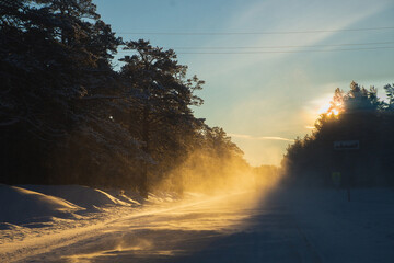Frozen road in Arkhangelsk region and sunny majestic conifeur winter forest. Strong frost, view from car