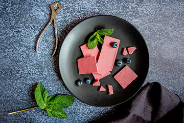Pink or ruby chocolate, trendy dessert on a black plate on dark backround