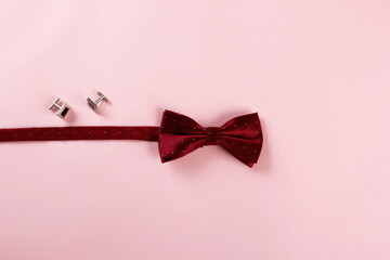 Red bow tie on pink background, selective focus, copy space