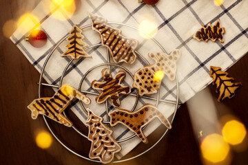 Holiday ginger cookies on a baking rack, on wooden table with kitchen towel. Soft focus. Top view, flat lay.