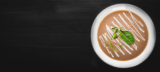 Creamy Mushroom Soup in a white plate on dark wooden table