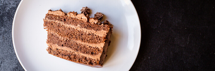 piece of chocolate cake brown cream sweet dessert on a white plate ready to eat on the table for healthy meal snack top view copy space for text food background rustic image