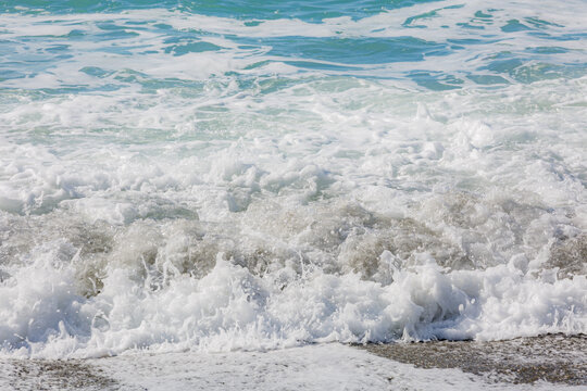 Blue sea water waves with white foam and bubbles. Winter see. Riva Trigoso on ligurian coast