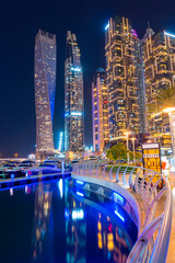 Night view to Dubai Marina panorama. Luxury skyscrapers and boats represent beautiful Dubai. Amazing colors reflect on the water. Shot at blue hour.