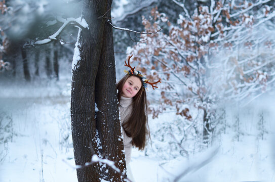 fairy girl with deer horns in winterforest. Beautiful mystery woman. Christmas snow fairy tale.characters of the fairy forest