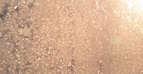 Shiny golden abstract background. Defocused sunlight through frosty patterns on the glass