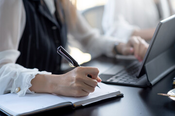 Fototapeta premium Businesswoman taking notes and working with laptop at office.