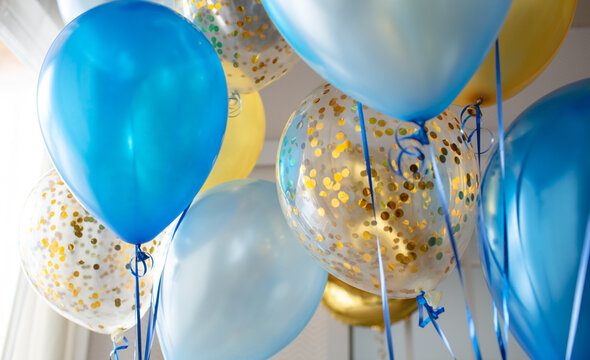 Fototapeta Blue and transparent balloons with golden confetti on the background of a large window. Light interior 