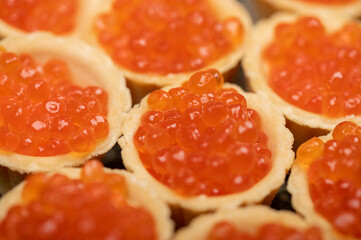 Tartlets with salmon caviar on a platter. Close-up, selective focus.