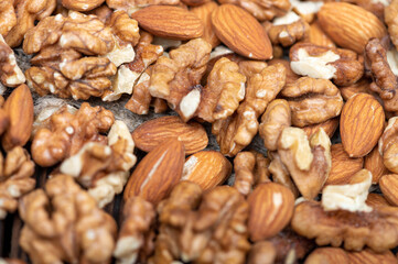 Almonds and walnuts scattered on the table. Close-up, selective focus.