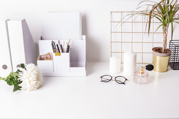 Cute feminine stuff on white table with glasses and flower, office background,