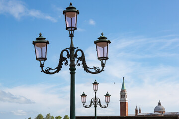 Fototapeta na wymiar 3-headed lanterns lining up towards Campanile tower of Venice, Italy