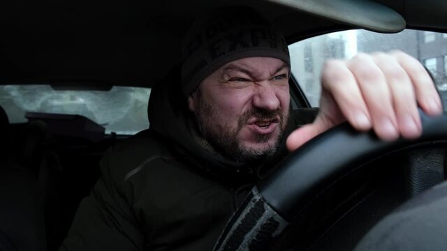 The nervous driver yells and hits the steering wheel. Nervous disorder, breakdown concept.