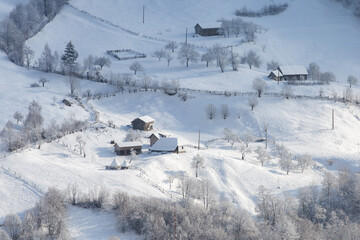 Winter frosty landscape of the beautiful Transylvanian village, Bran, with fresh snow, at the foot of the Carpathian Mountains