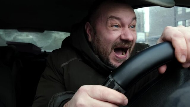 The driver laughs crazy in the car. Nervous mad laughter.