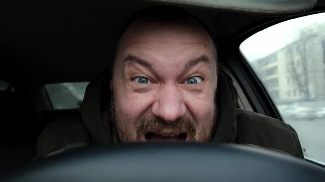 The driver laughs crazy in the car. Nervous mad laughter.