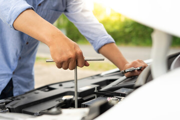 Hand of a car mechanic with a wrench Winding and checking engine readiness And engine oil level, engineer concept and car repair